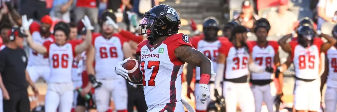 REDBLACKS player running with the football