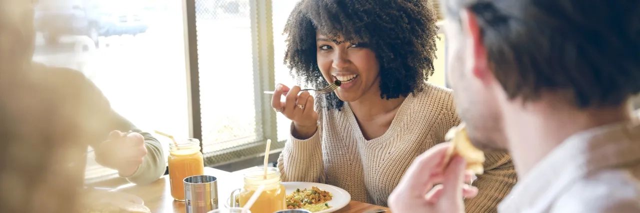 A woman eating with friends at a restaurant