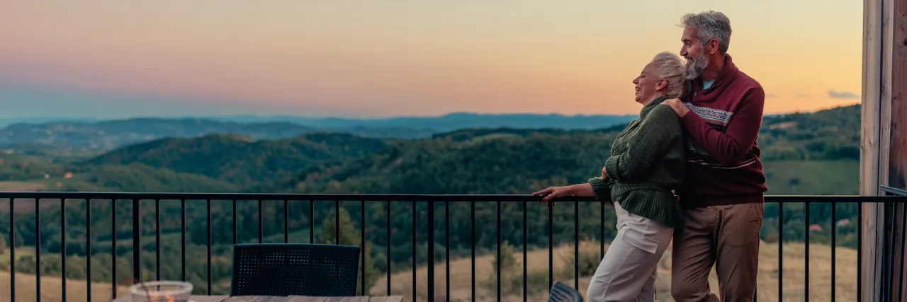 A senior couple admiring the sunset overtop the mountains.