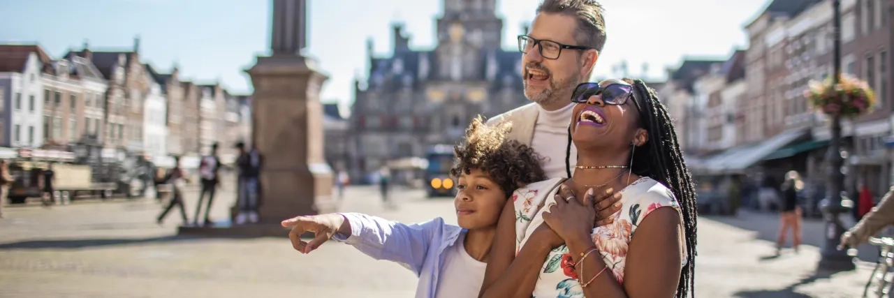 A family of three laughing together while travelling. 