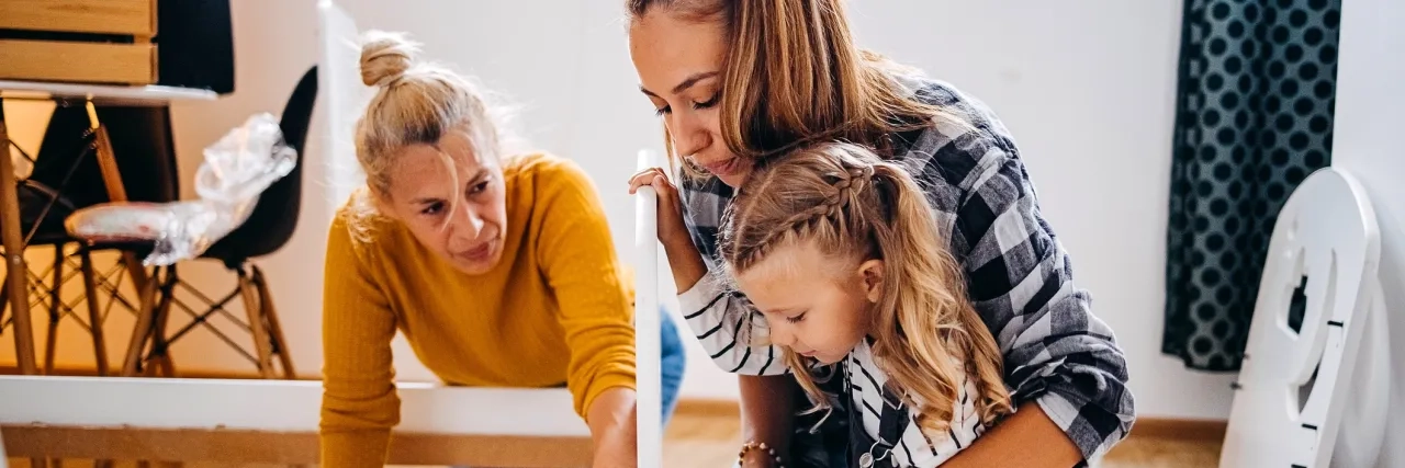 Mother, daughter, and grandmother putting together bed in a new home