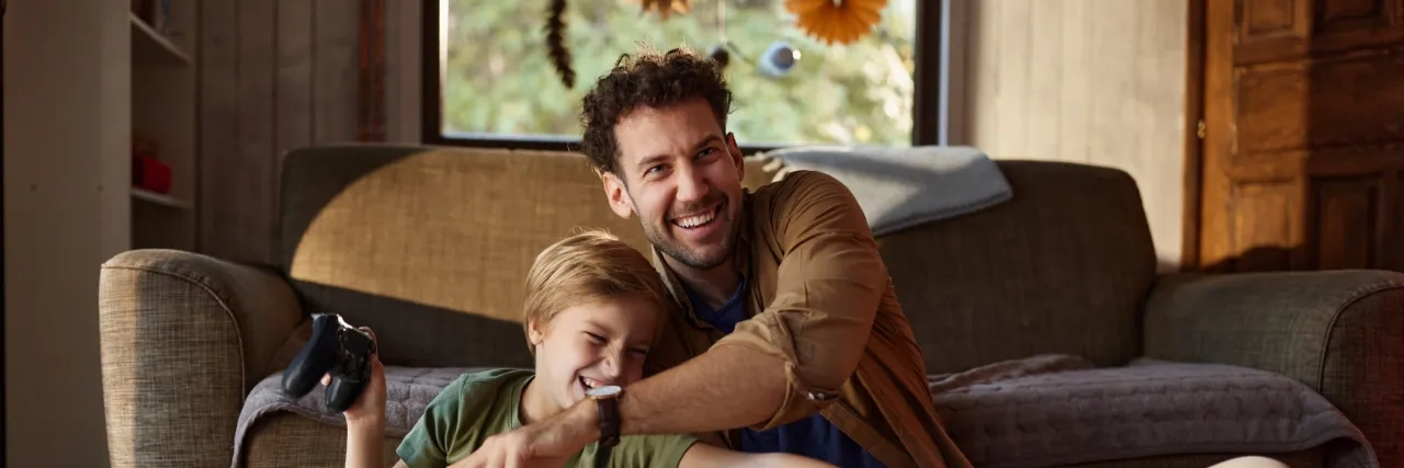 Man playing games with son indoors