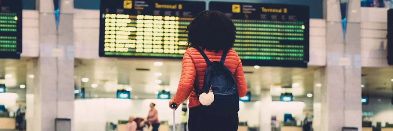 Woman standing at the airport with her luggage