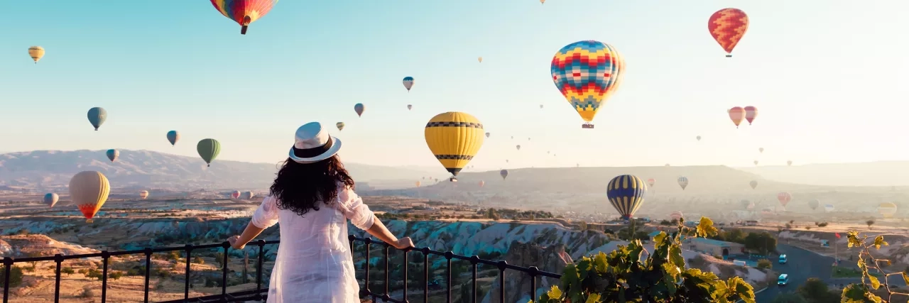 Woman watching hot air balloons fly in Cappadocia, Turkey 