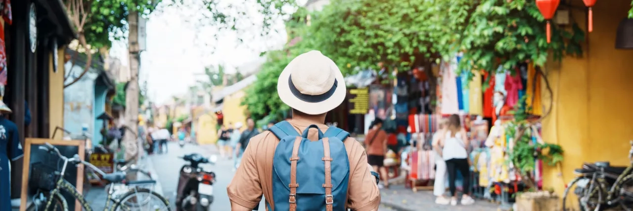 Solo traveler sightseeing at Hoi An ancient town in central Vietnamling with backpack and hat. landmark and popular for tourist attractions. Vietnam