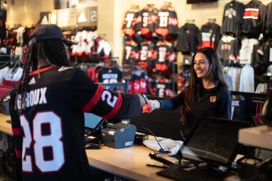 woman purchases items at hockey team merchandise store