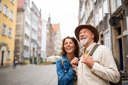 happy senior couple tourists outdoors in historic town