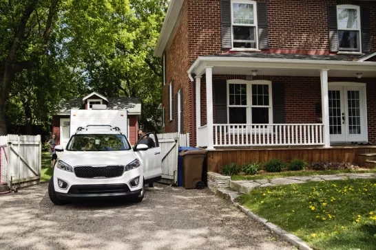 Family getting into their car parked in driveway of house