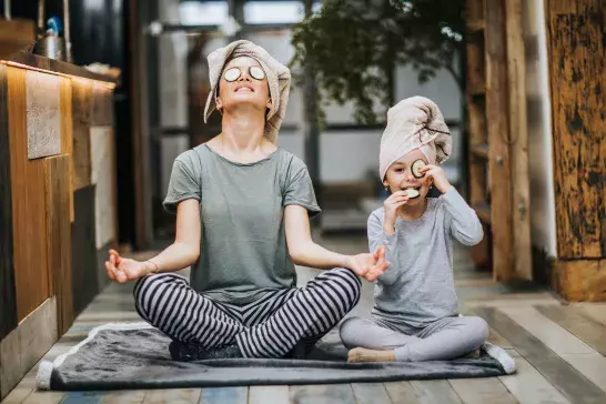 Mother doing yoga with daughter at home