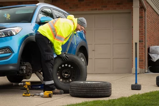 CAA changing tires in driveway