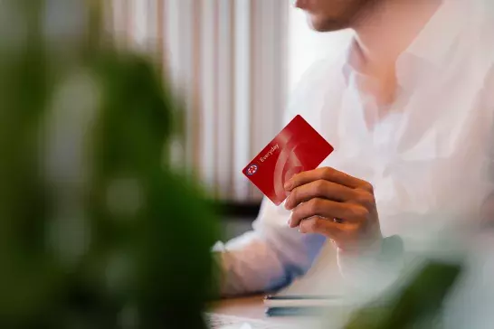 Person at desk holding membership card 