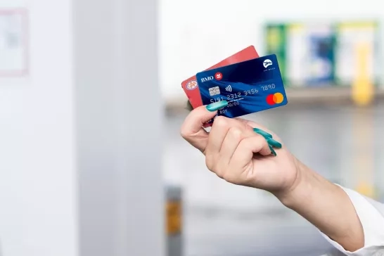 Person holding a BMO credit card at a Shell station