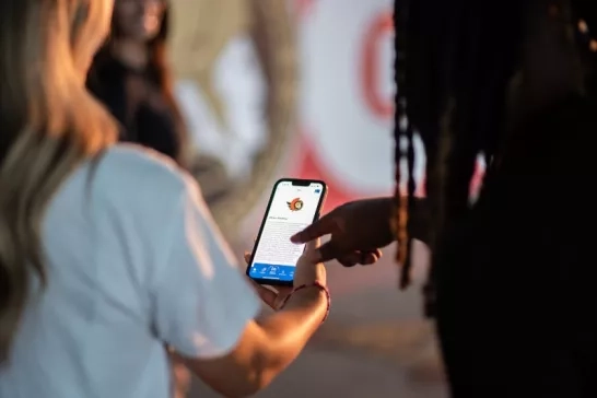 Two people using the CAA Mobile App to browse savings