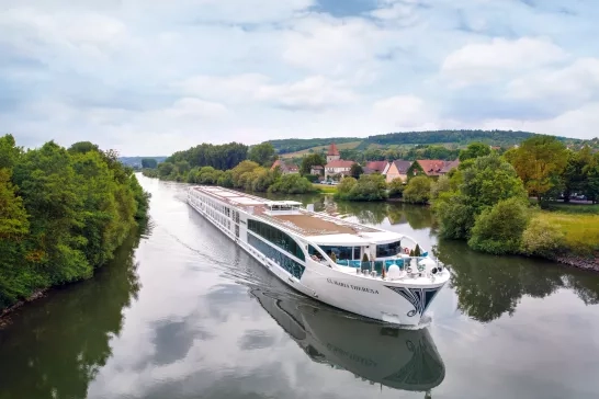 Exterior shot of a Uniworld Boutique River Cruises' ship going down a canal.
