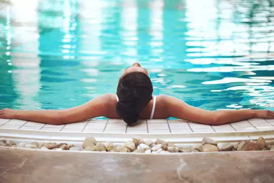 Woman relaxing in hotel swimming pool