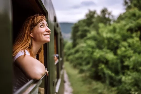 Young smiling woman looking out of the train window