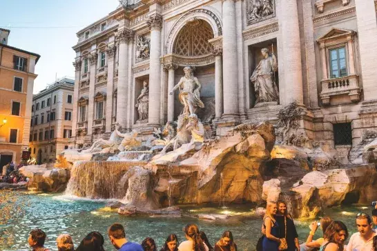 The iconic Trevi Fountain in Rome, surrounded by tourists enjoying the historic architecture and the beauty of the famous Baroque masterpiece.