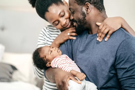 Dad holding baby with mother