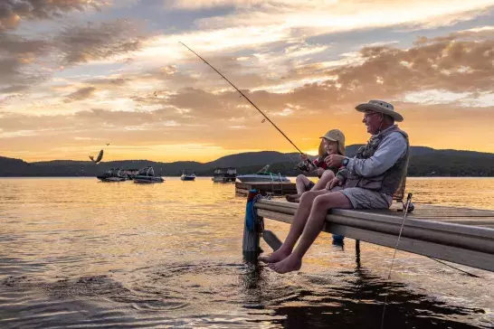 Grandpa and granddaughter going fishing at sundown together