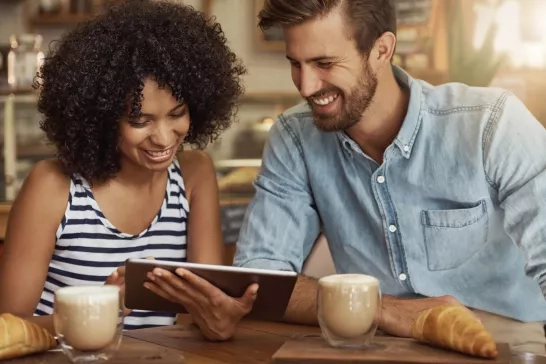 Husband and wife at a coffee shop reviewing a digital document