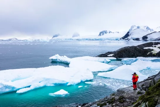 Tourist taking photos of frozen landscape in the Antarctica Peninsula