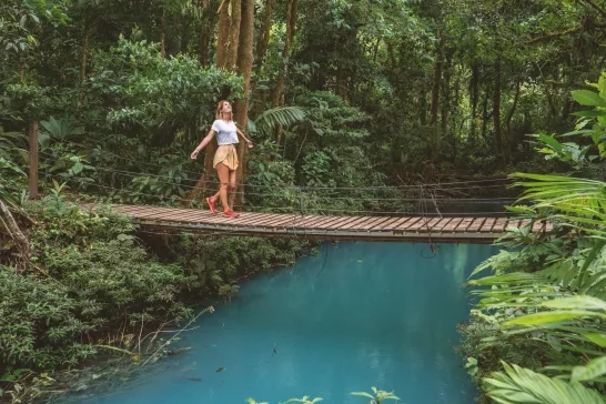 A woman hiking across a bridge through the cloud rainforest in Monteverde, Costa Rica.