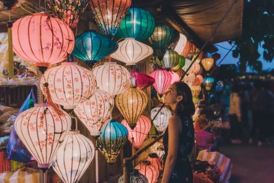 A woman admiring an array of lanterns in Hoi An, Vietnam.