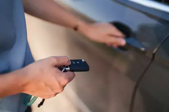 person holding car keys next to automobile