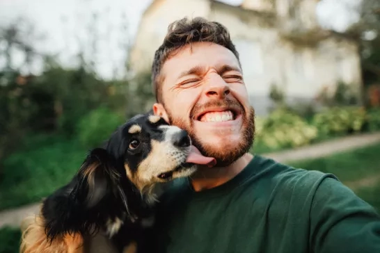 Pet dog licking their owners face outside