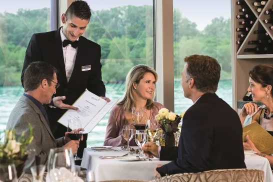 Waiter showing a family the menu onboard AmaWaterways.