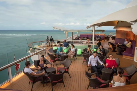 Happy travellers enjoying a drink on the Celebrity Cruise sunset bar.