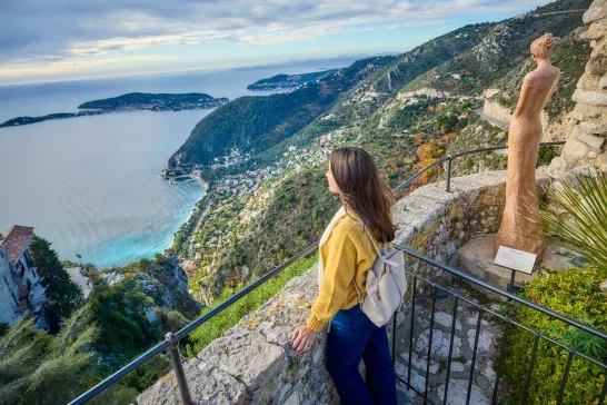 A woman admiring the shoreline from a mountaintop in Eze, France