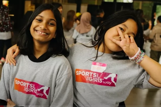 two young girls smile at the camera wearing sports day the girls way tshirts