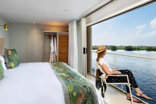Woman admiring her view from the stateroom onboard AmaWaterways' Zambezi in Africa.