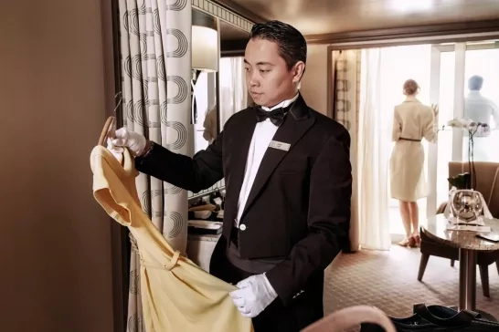 A butler hanging up a passenger's dress onboard a Silversea Cruise. 