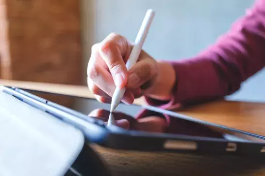 Closeup of hand writing using a digital tablet stylus