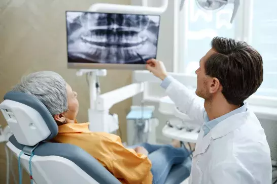 Dentist reviewing x-ray image with patient