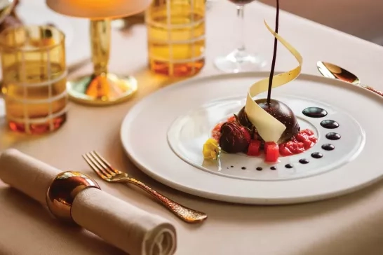 A well-plated dessert plate with a glass of wine onboard Silversea Cruises.