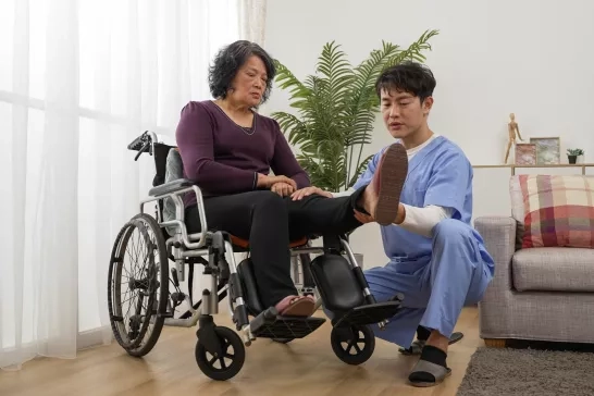 Health care nurse helping woman rehab injured leg