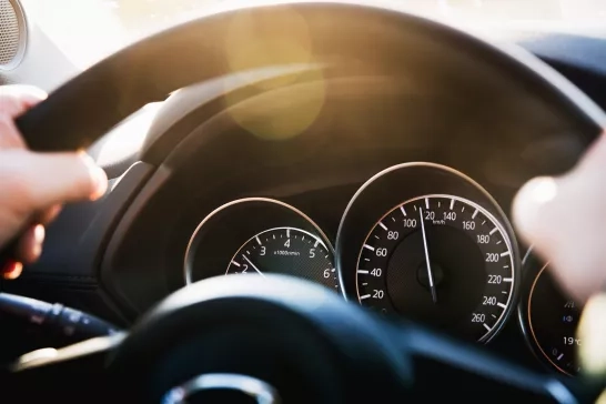 Speedometer of a car close-up, with the arrow frozen at a speed of 120 km/h. Details and interior of a black luxury car