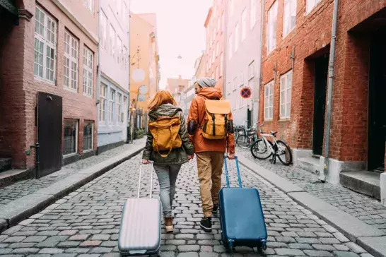 couple walking down the street and pulling the suitcases