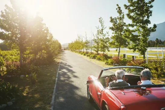 Couple, convertible and driving road trip or travel journey in vineyard, adventure or transportation. People, nature and tourism holiday for explore together in retirement,