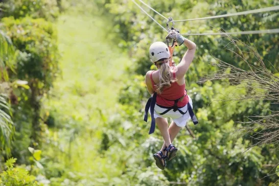 A woman enjoying a zip line tour in the jungle of Monteverde, Costa Rica.