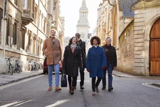 A group of mature travellers walking through Rome in the fall.