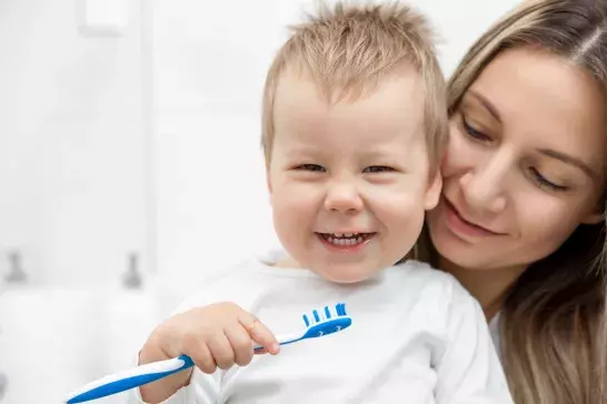 Mother teaching son how to brush teeth