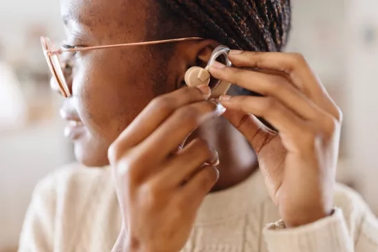 Woman putting on hearing aid