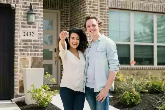 Couple standing in front of their new home