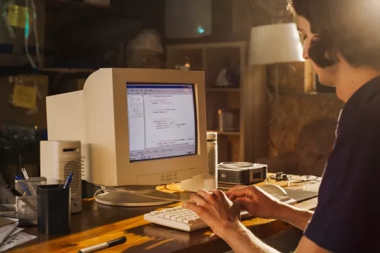 person typing at old computer