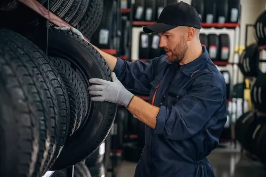 Worker inspecting shelf filled with tires