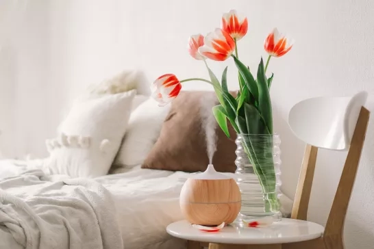 oil diffuser on chair next to bed